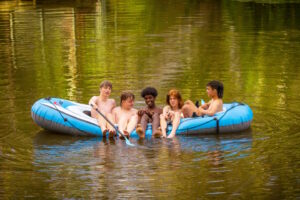 Five teenage boys in a dingy on a lake